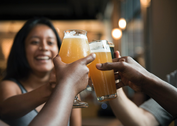 Friends clinking beer glasses at a brewery